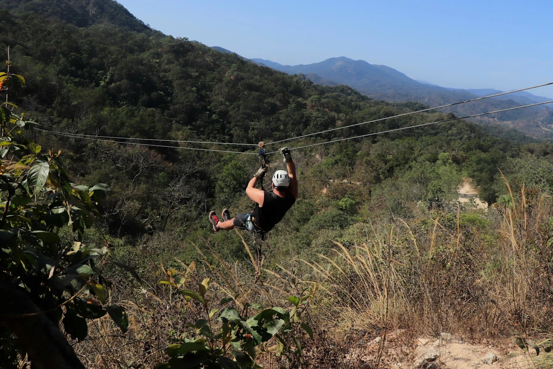 Adventure traveler ziplining over a desert canyon in Cabo San Lucas, Mexico