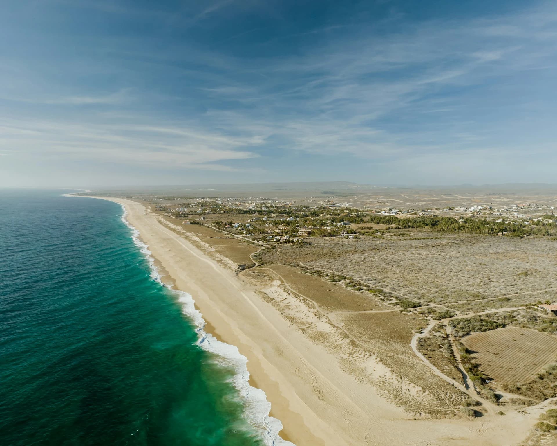 Stormy September sky over the Pacific coast near Todos Santos, Baja California Sur, with big surf and green desert hills