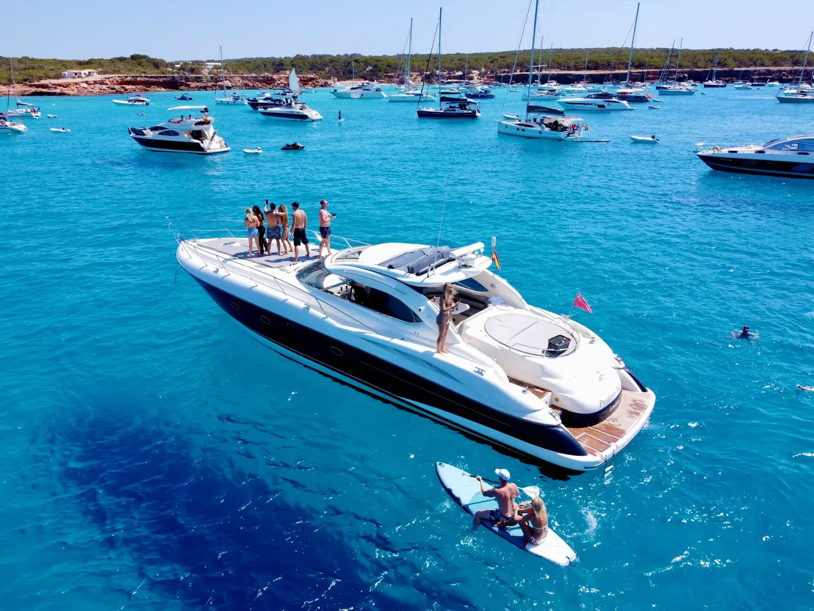Private luxury yacht anchored near El Arco in Cabo San Lucas with turquoise water and the Land's End rock formations behind