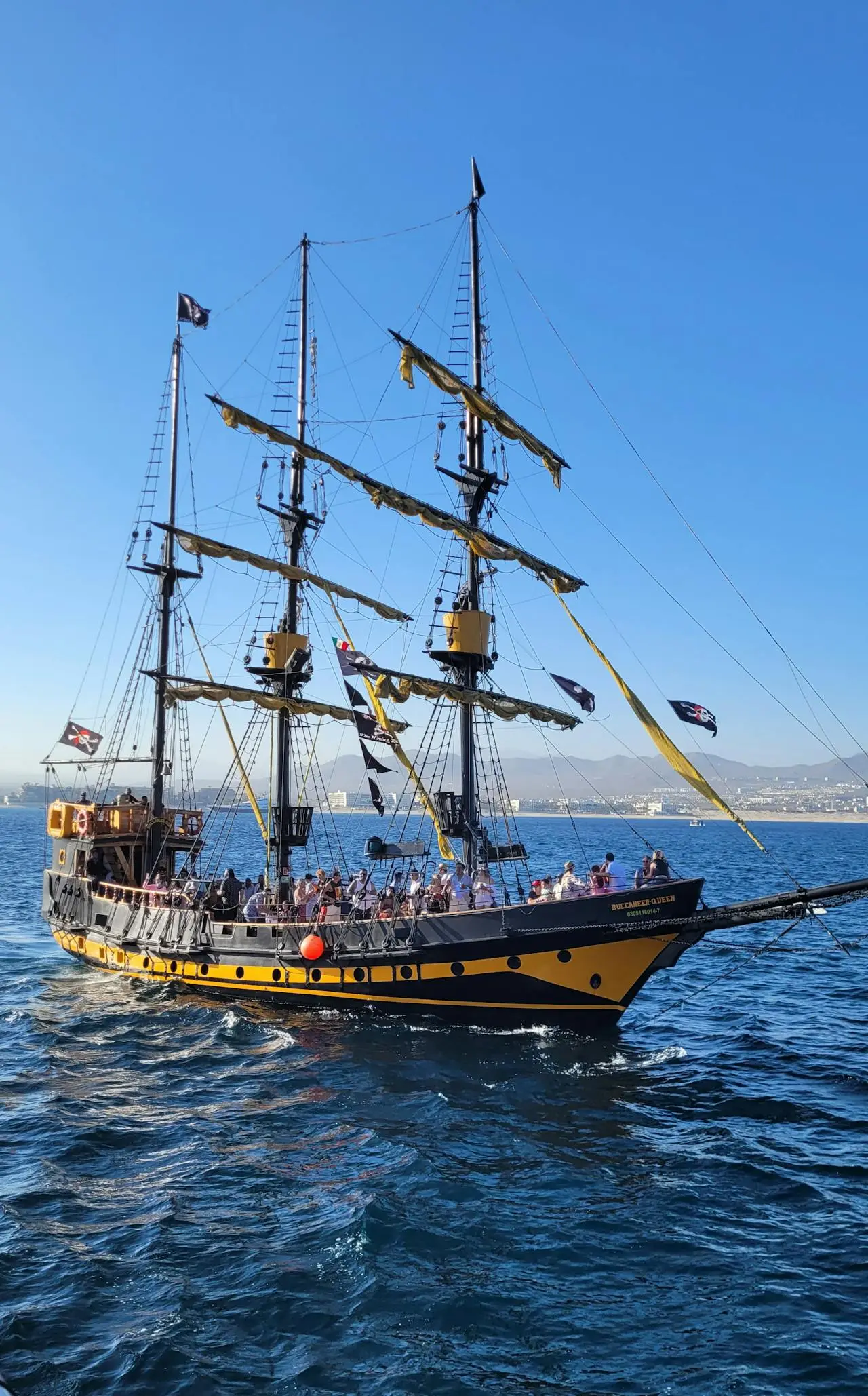 El galeón barco pirata Buccaneer Queen navegando frente al Arco de Land's End al atardecer en Cabo San Lucas